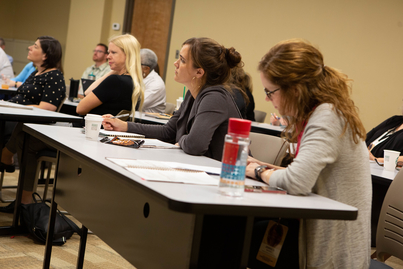 Attendees take notes during a session